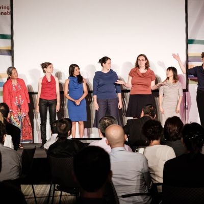 Members of the pop up theatre standing on stage, moderator introduced them to the crowd (sitting in the foreground of picture). Picture was taken at the last NDC Conference.